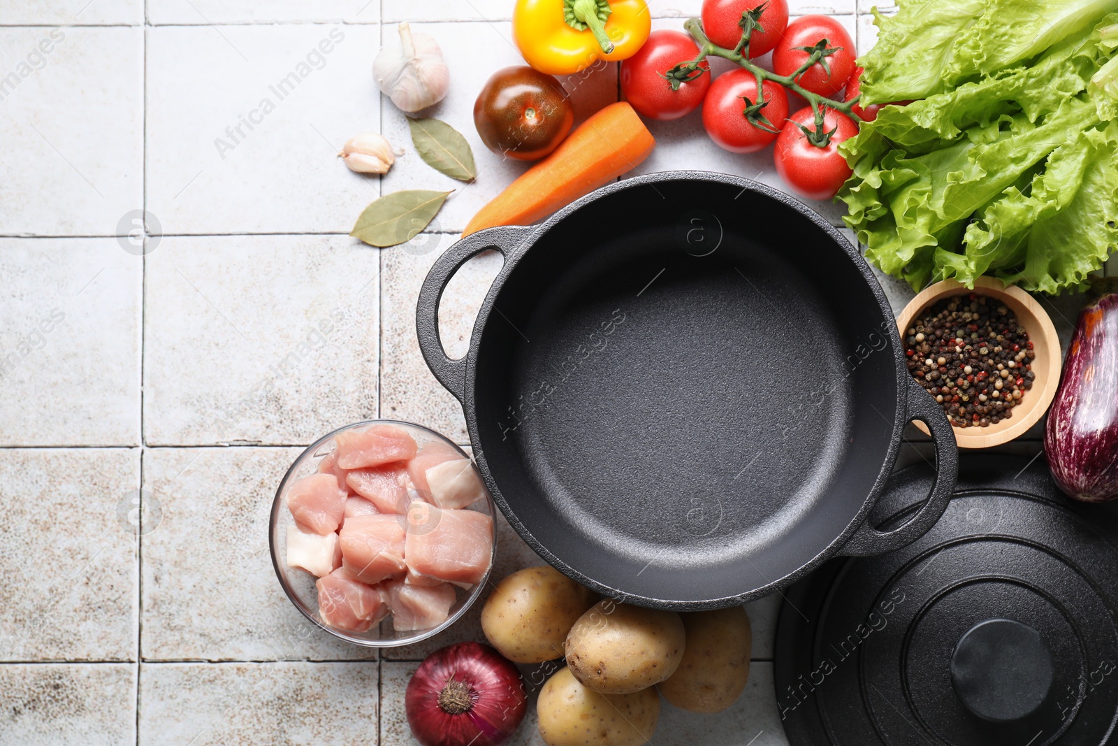 Photo of Uncooked ingredients for stew on tiled table, flat lay