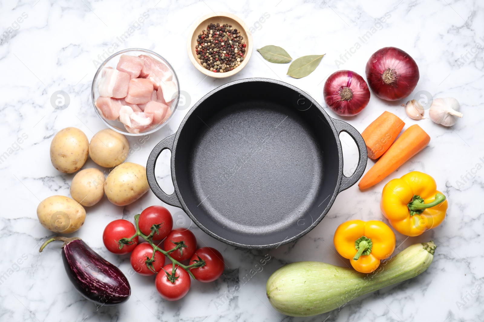 Photo of Uncooked ingredients for stew on white marble table, flat lay