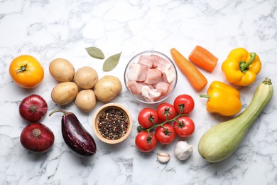 Photo of Uncooked ingredients for stew on white marble table, flat lay