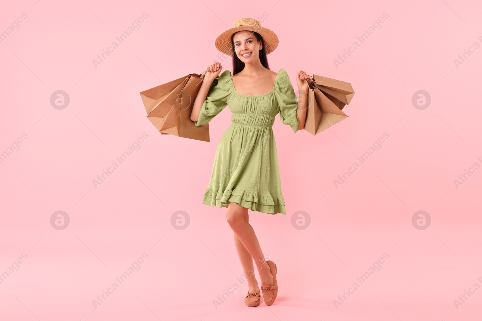 Photo of Smiling woman with shopping bags on pink background