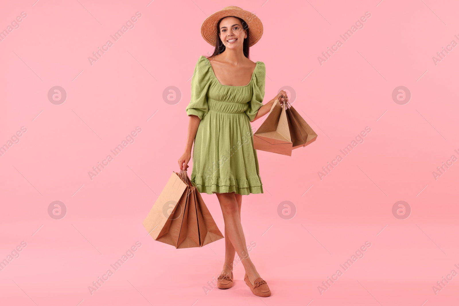 Photo of Smiling woman with shopping bags on pink background