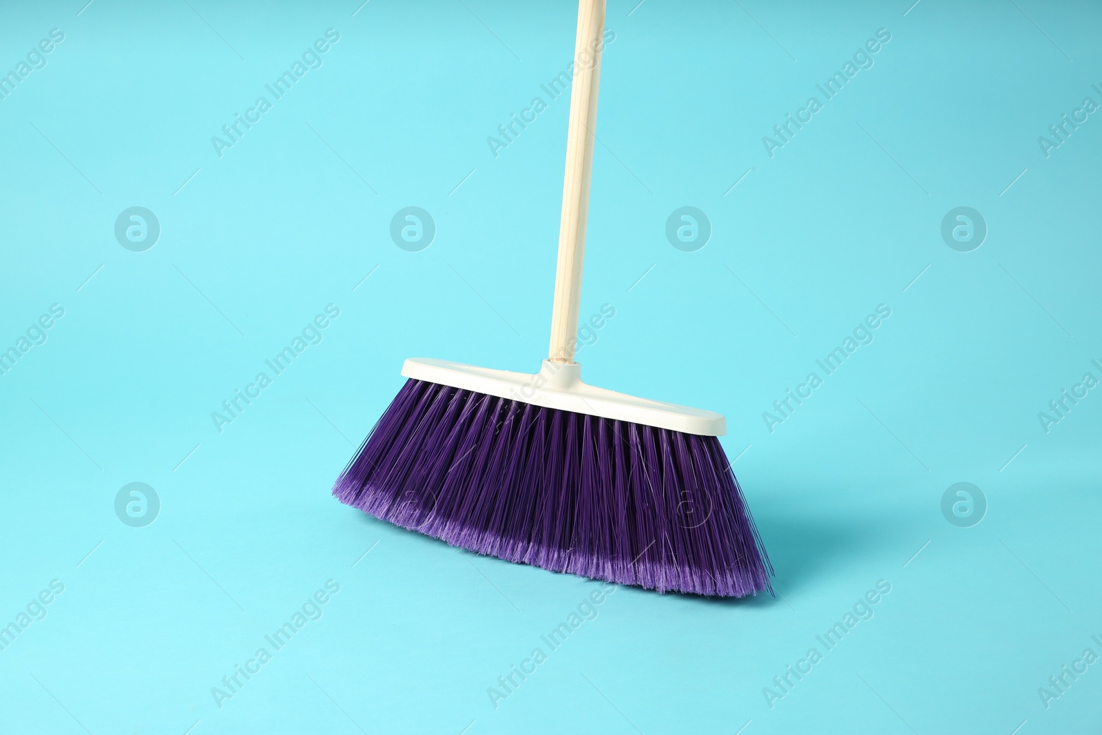 Photo of One cleaning broom on light blue background