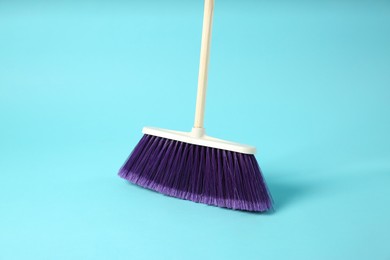 Photo of One cleaning broom on light blue background