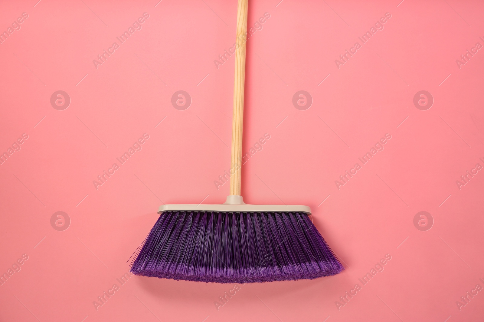 Photo of One cleaning broom on pink background, top view