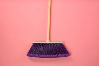 Photo of One cleaning broom on pink background, top view