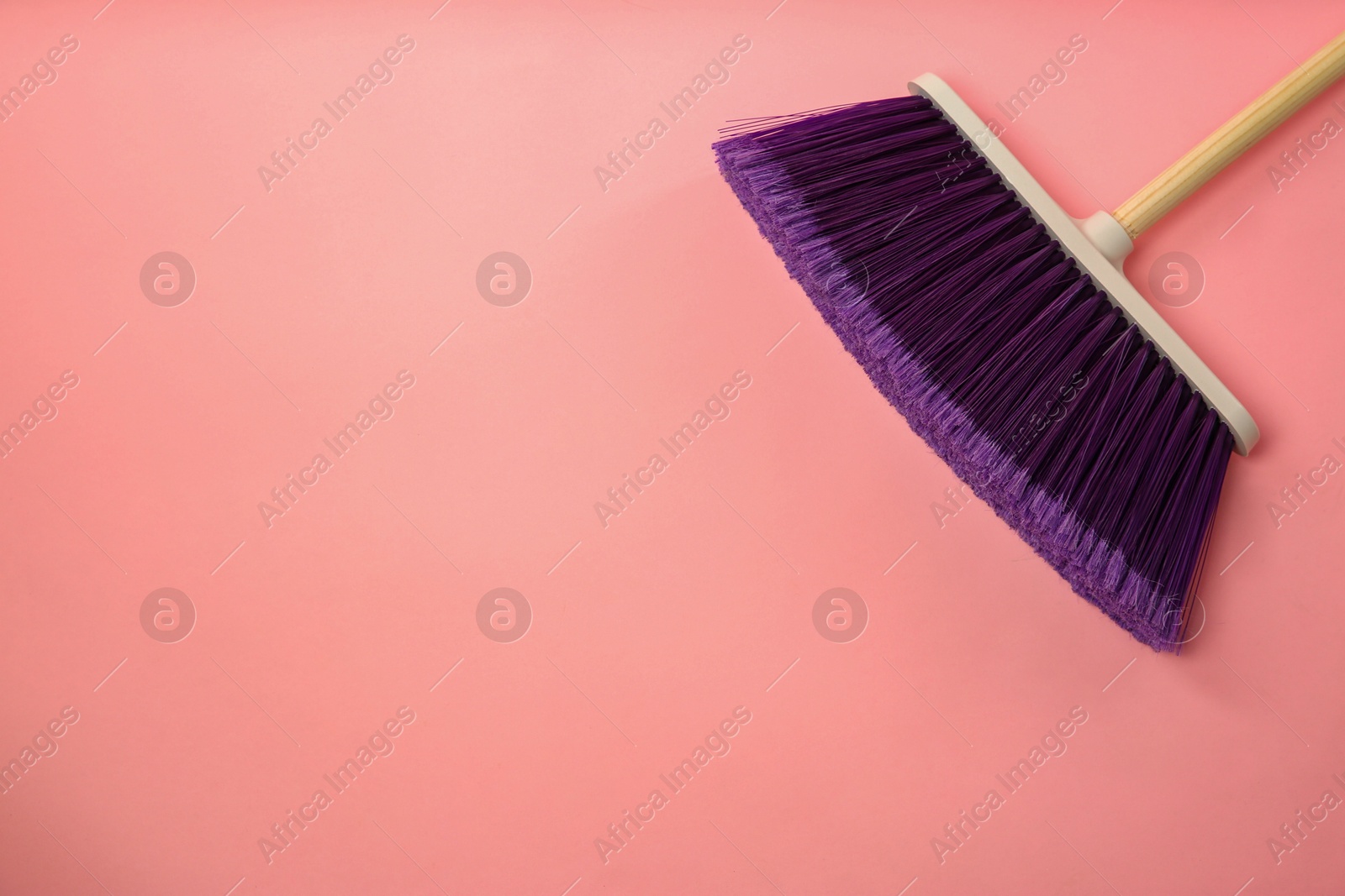 Photo of One cleaning broom on pink background, top view. Space for text