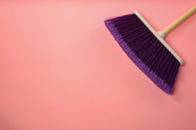 Photo of One cleaning broom on pink background, top view. Space for text