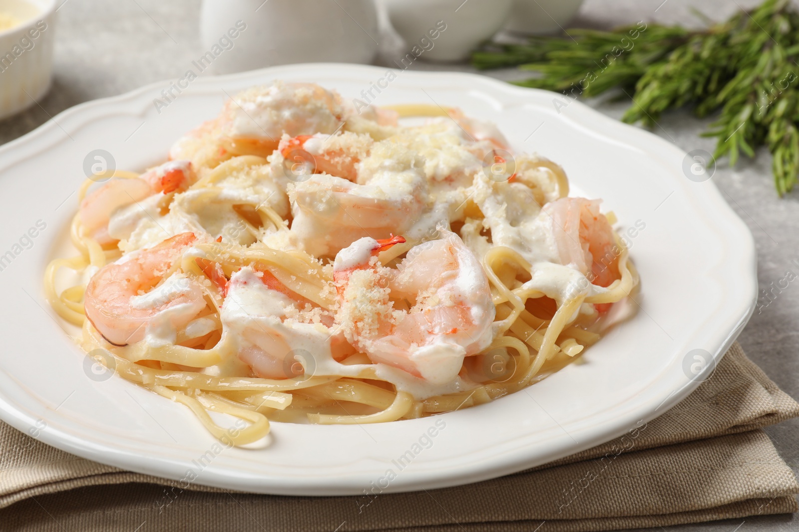 Photo of Delicious pasta with shrimps served on light table, closeup