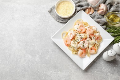 Photo of Delicious pasta with shrimps served on light table, flat lay. Space for text