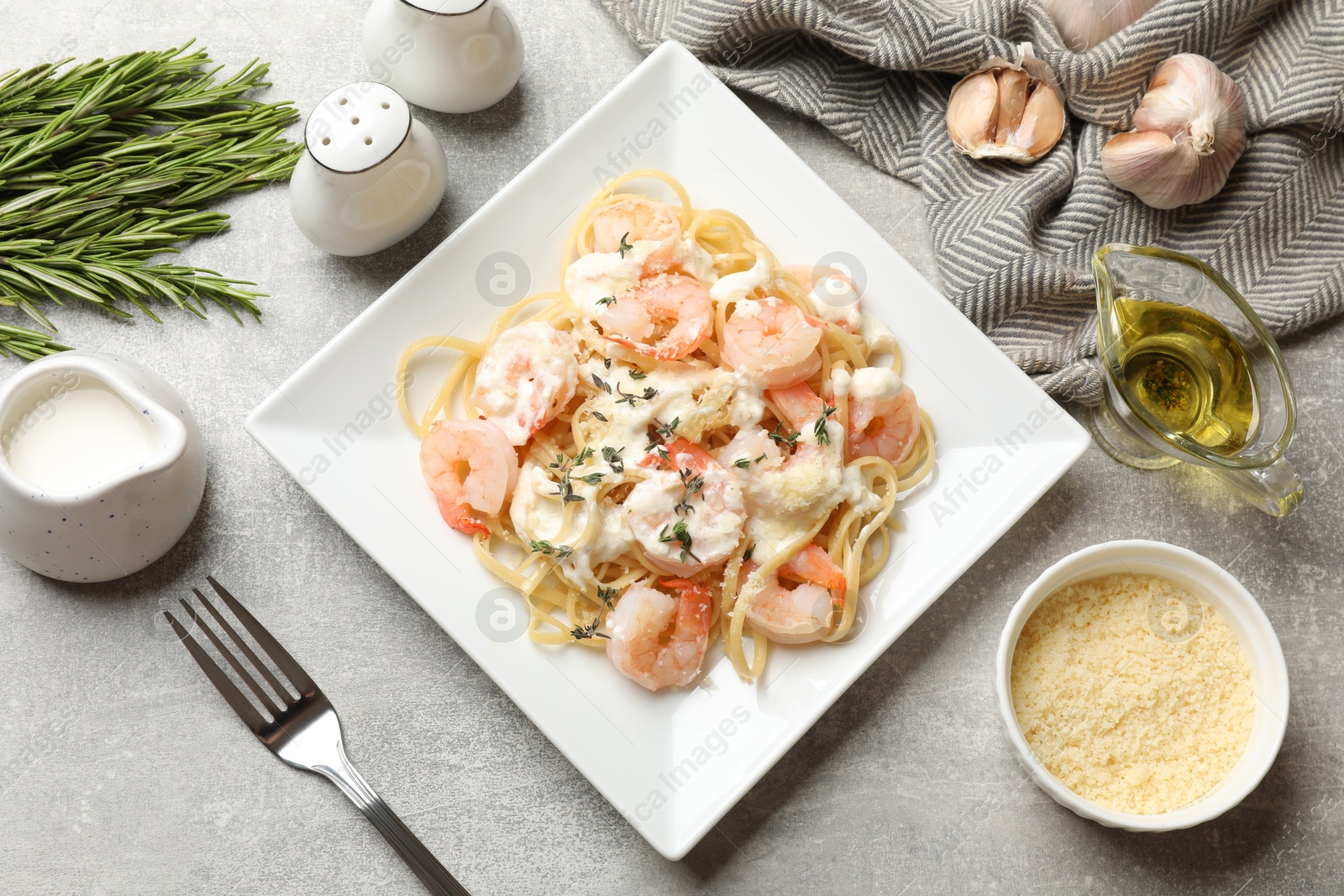 Photo of Delicious pasta with shrimps served on light table, flat lay