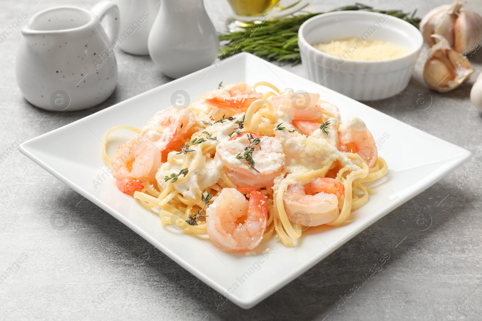 Photo of Delicious pasta with shrimps served on light table, closeup