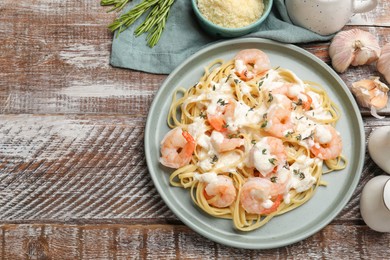 Photo of Delicious pasta with shrimps served on wooden table, flat lay. Space for text