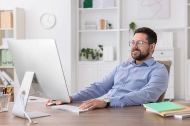 Smiling businessman working at table in office