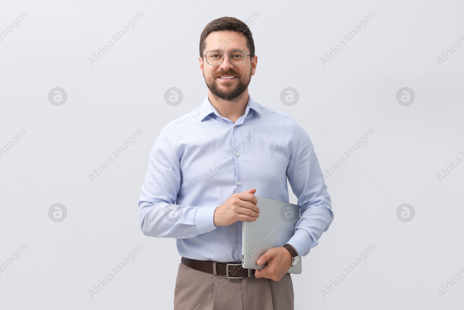 Photo of Portrait of smiling businessman with laptop on grey background