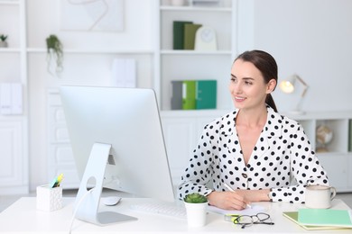 Smiling businesswoman working at table in office