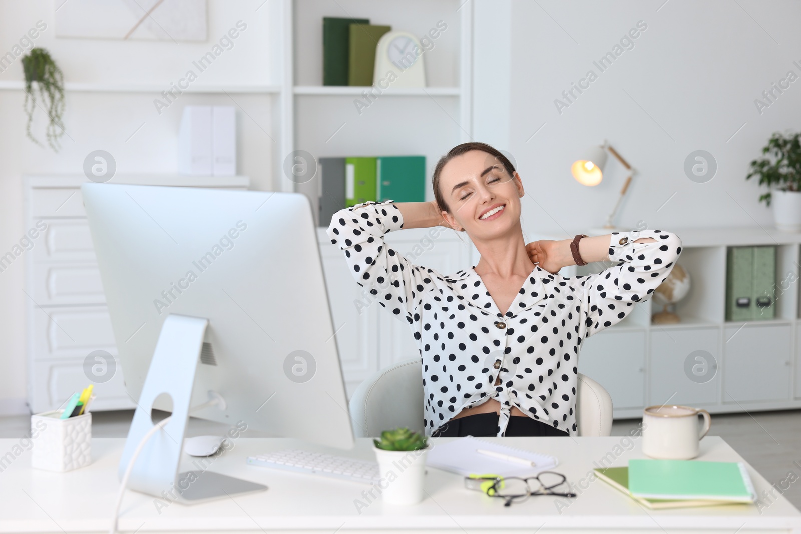 Photo of Smiling businesswoman relaxing at workplace. Break time