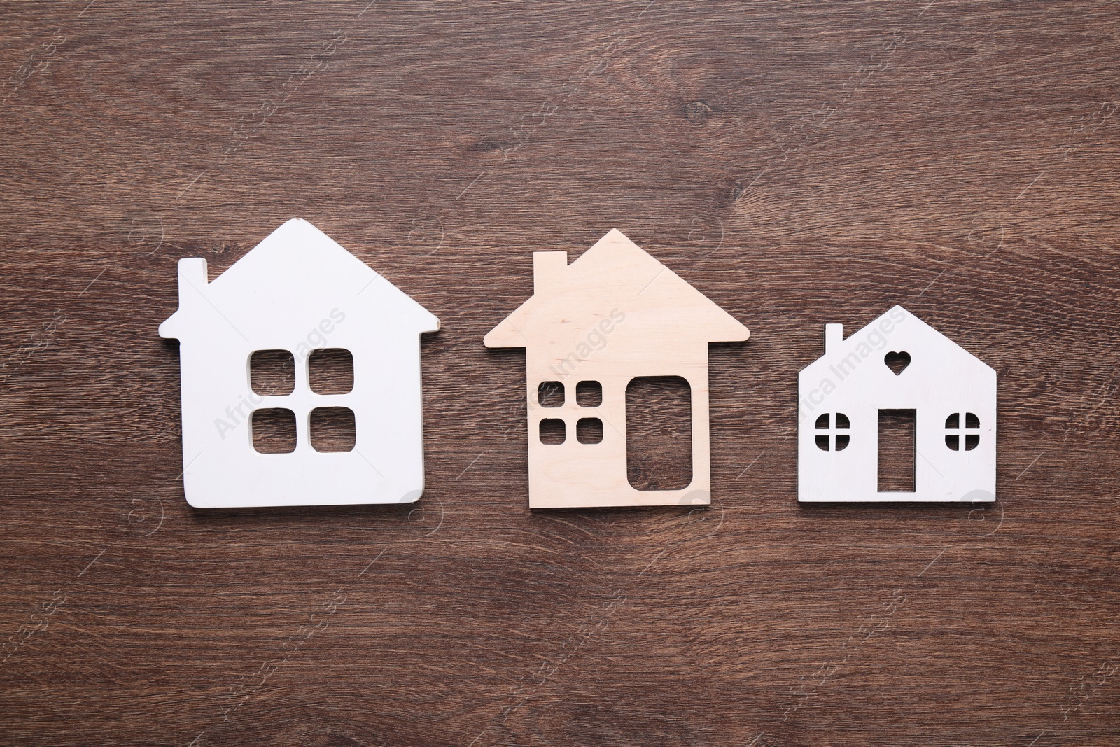 Photo of House figures on wooden background, flat lay