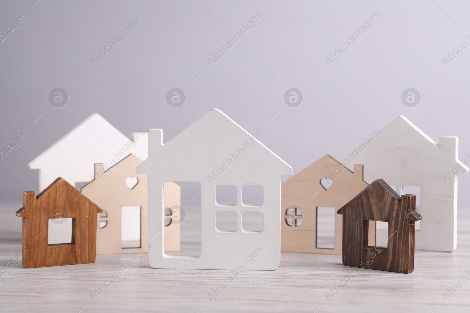 Photo of House hunting. House figures on wooden table