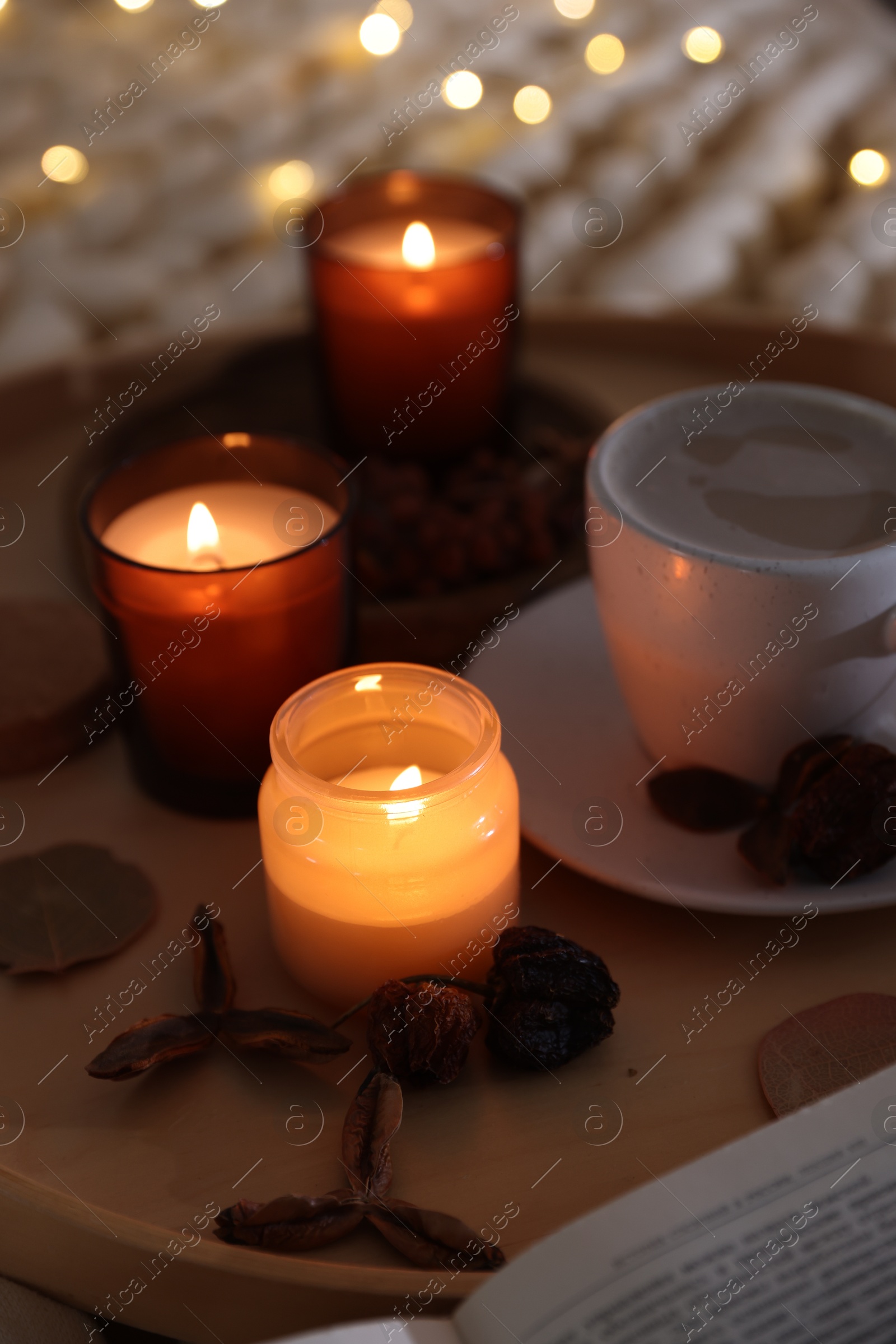 Photo of Burning candles, coffee and decor on tray, closeup. Autumn atmosphere