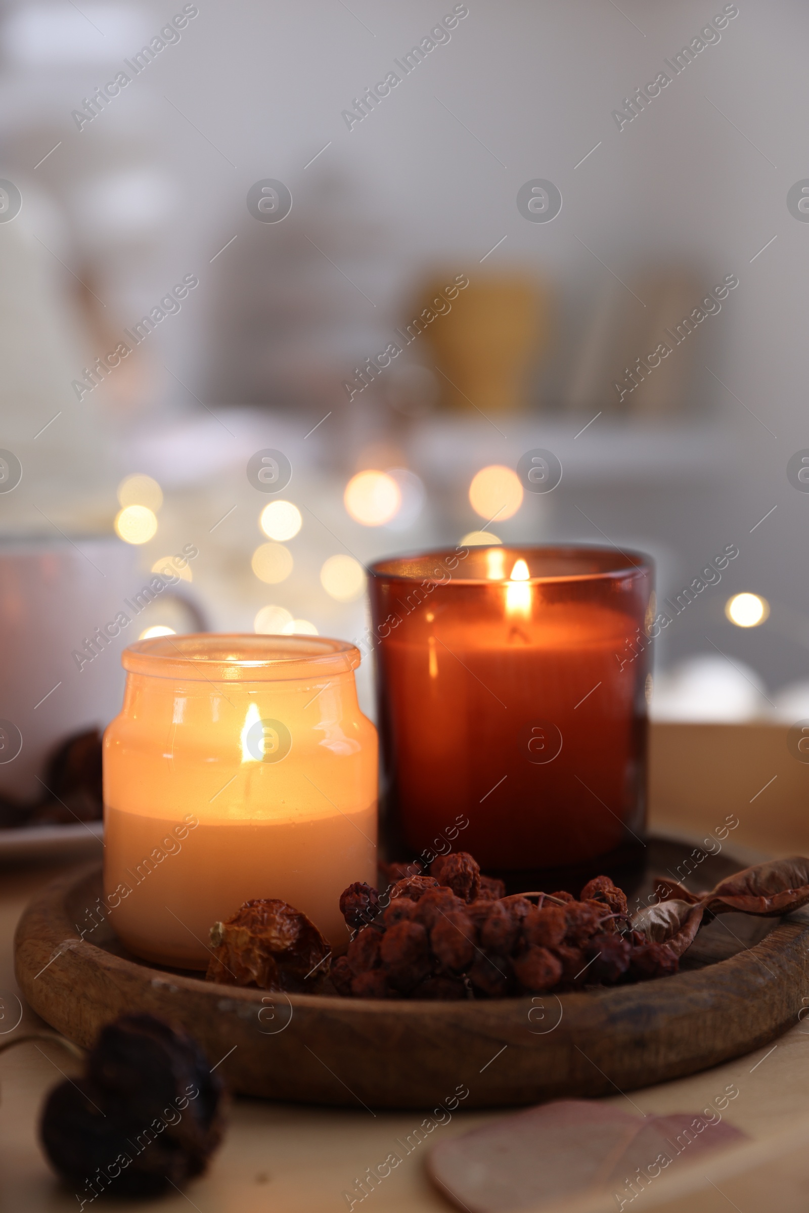 Photo of Burning candles and decor on tray indoors, closeup. Autumn atmosphere