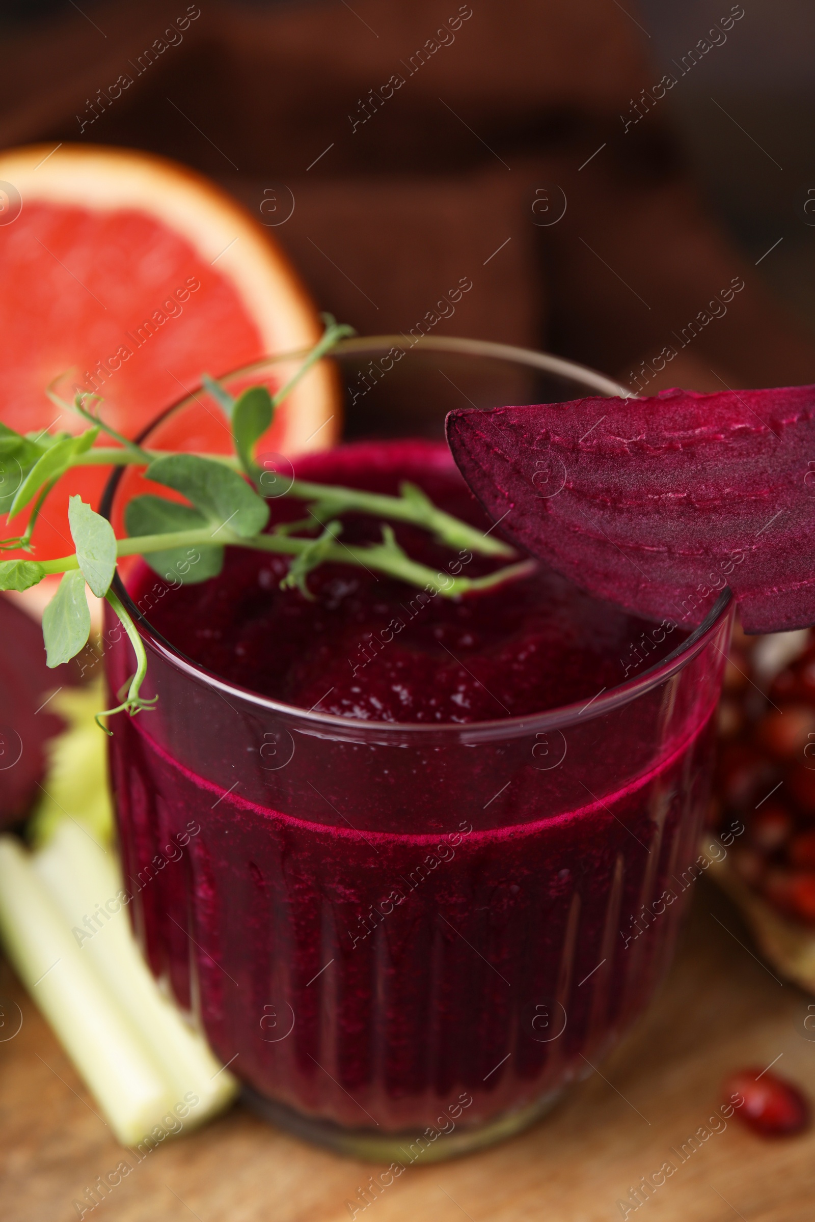 Photo of Tasty beetroot smoothie with microgreens in glass on table, closeup. Vegan drink