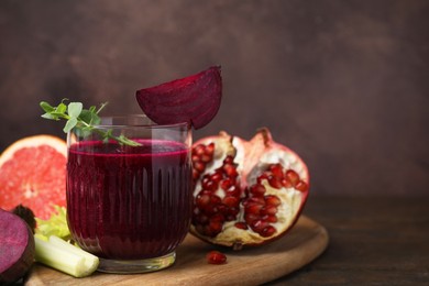 Tasty beetroot smoothie in glass, fresh vegetables and fruits on wooden table, closeup with space for text. Vegan drink