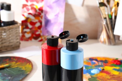 Photo of Acrylic paints of different colors on table indoors