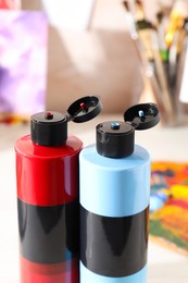 Acrylic paints of different colors on table, closeup