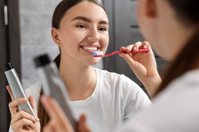 Beautiful woman brushing her teeth in bathroom