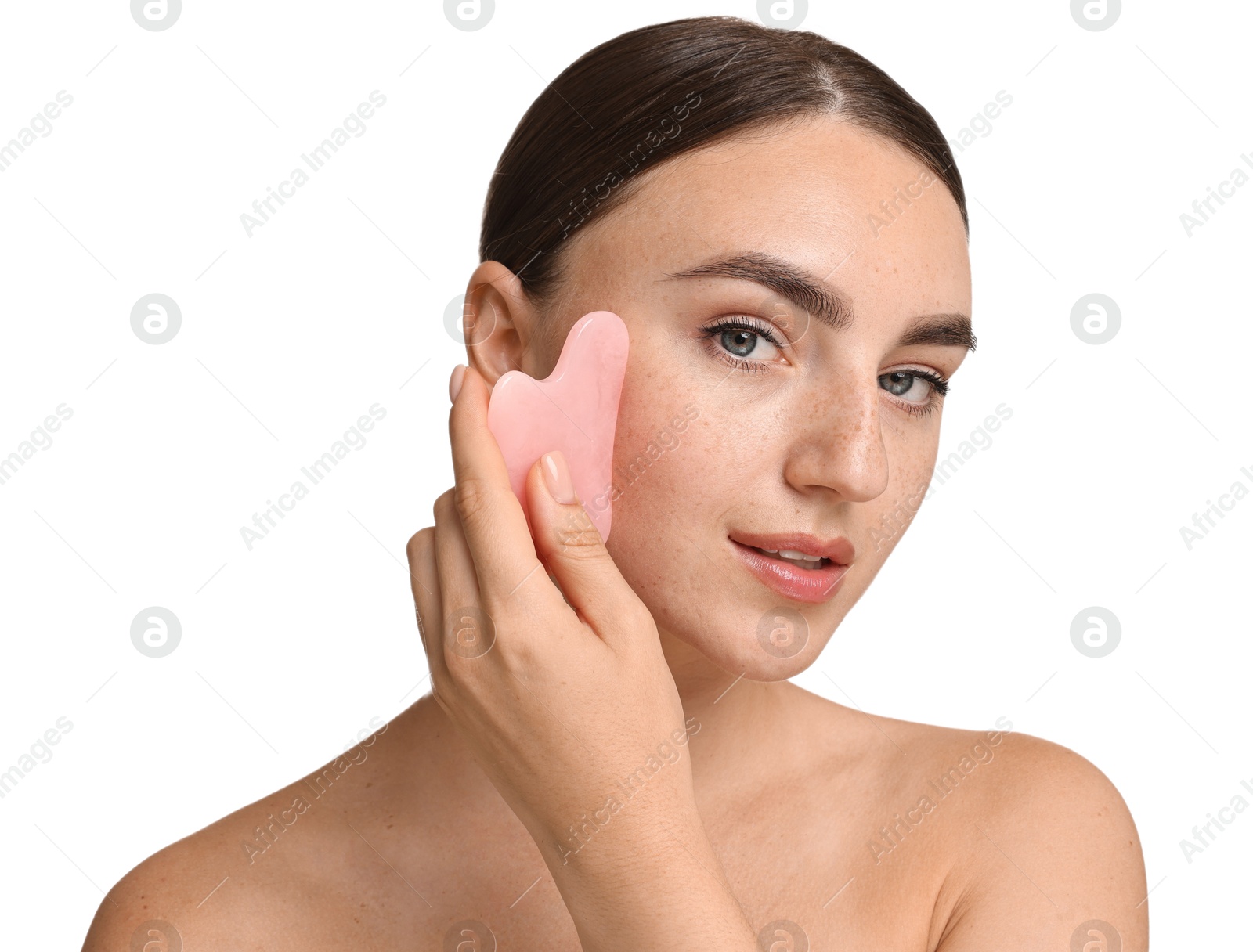 Photo of Beautiful young woman doing facial massage with gua sha tool on white background