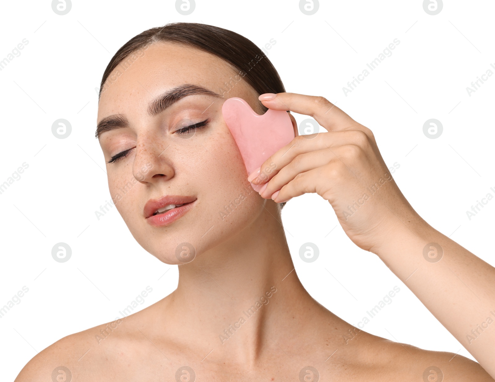 Photo of Beautiful young woman doing facial massage with gua sha tool on white background