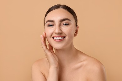 Beautiful young woman with healthy skin on beige background