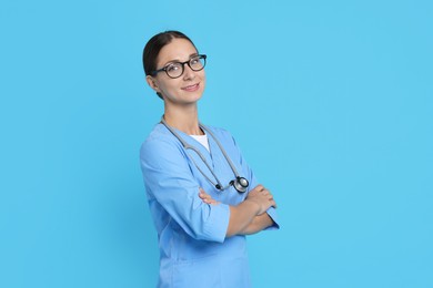 Nurse in medical uniform with stethoscope on light blue background