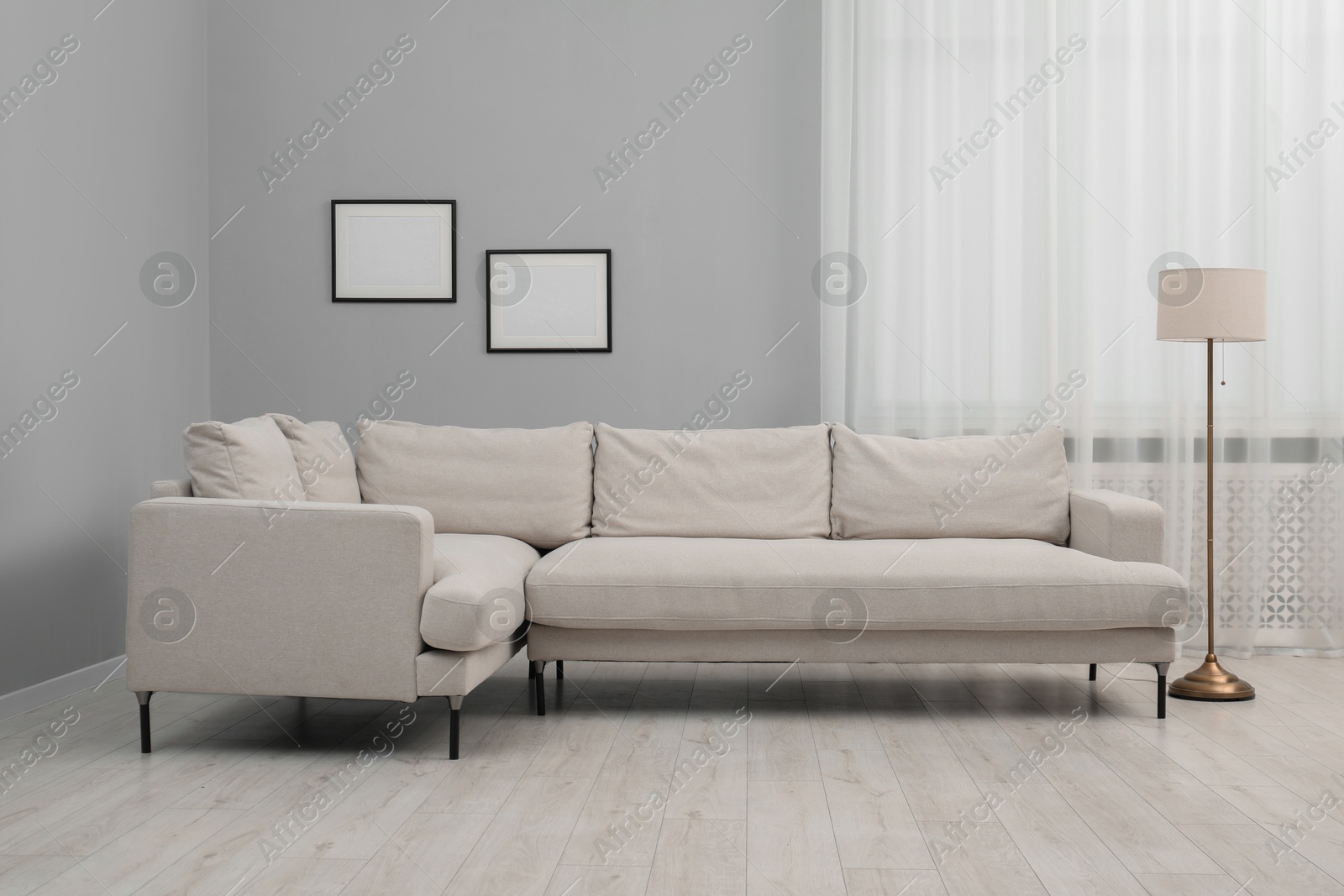 Photo of Stylish room interior with comfortable sofa and lamp