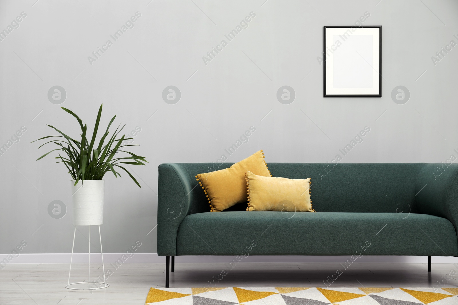 Photo of Stylish room interior with comfortable sofa and houseplant