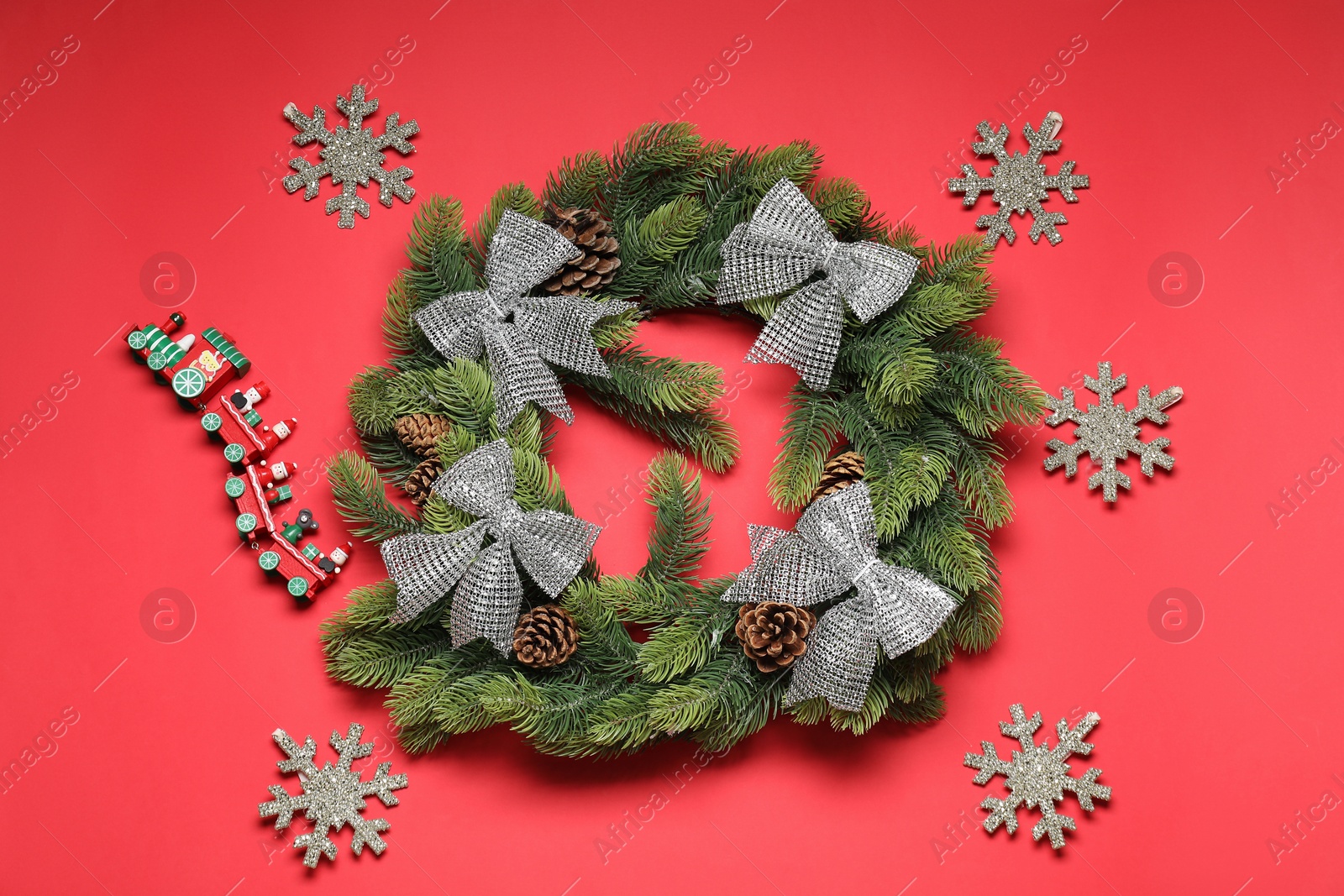 Photo of Christmas composition with festive decor on red background, flat lay