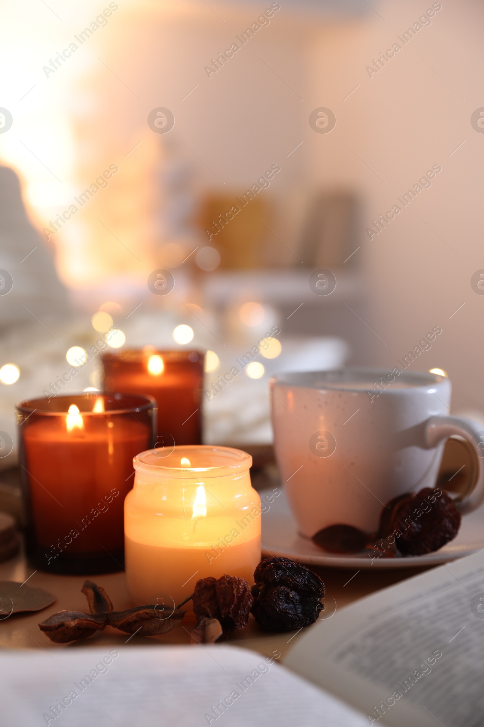 Photo of Burning candles, coffee and decor on tray indoors. Autumn atmosphere