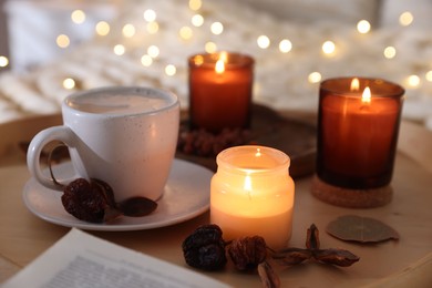 Photo of Burning candles, coffee and decor on tray, closeup. Autumn atmosphere