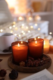 Photo of Burning candles and decor on tray indoors. Autumn atmosphere