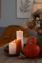 Photo of Tray with many burning candles and autumn decor on wooden table indoors