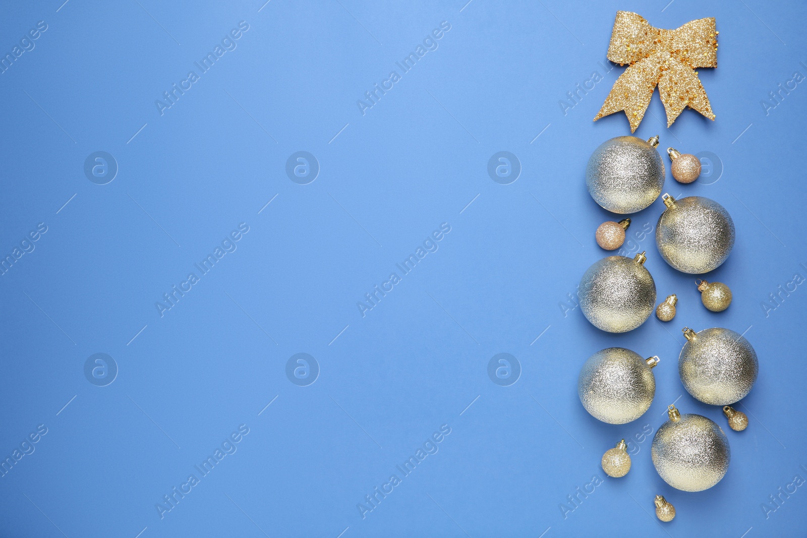 Photo of Christmas baubles and bow on blue background, flat lay. Space for text