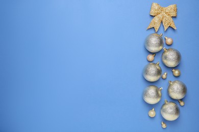 Photo of Christmas baubles and bow on blue background, flat lay. Space for text