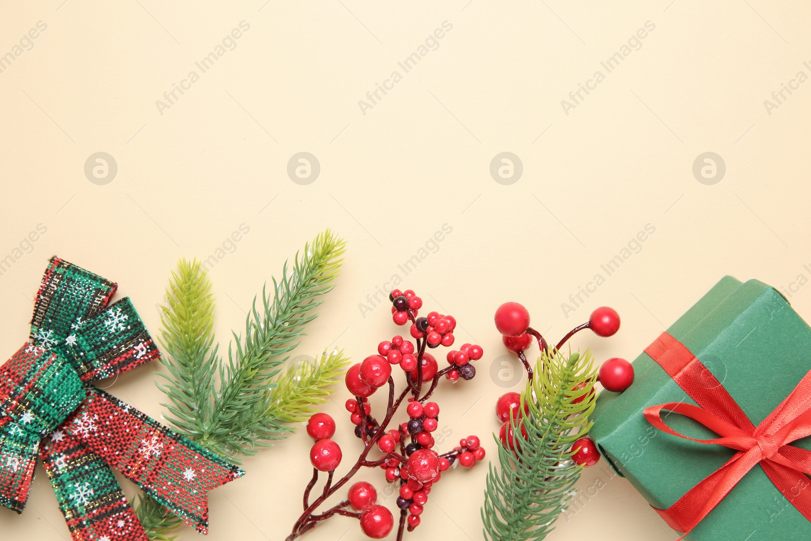 Photo of Flat lay composition with Christmas decor and gift box on beige background. Space for text