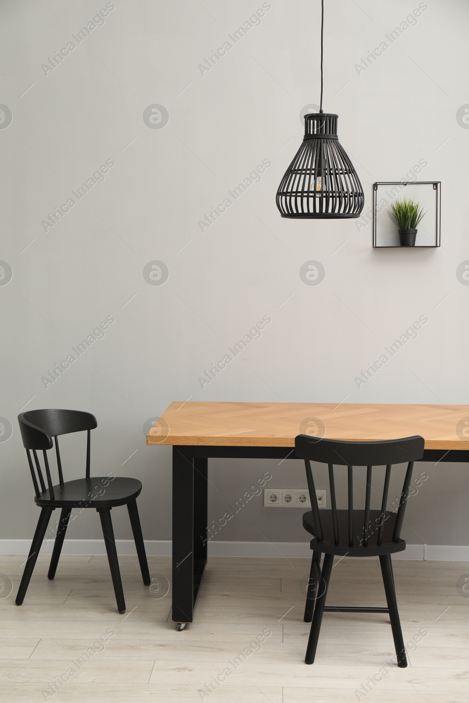 Photo of Wooden table with black chairs in stylish dining room