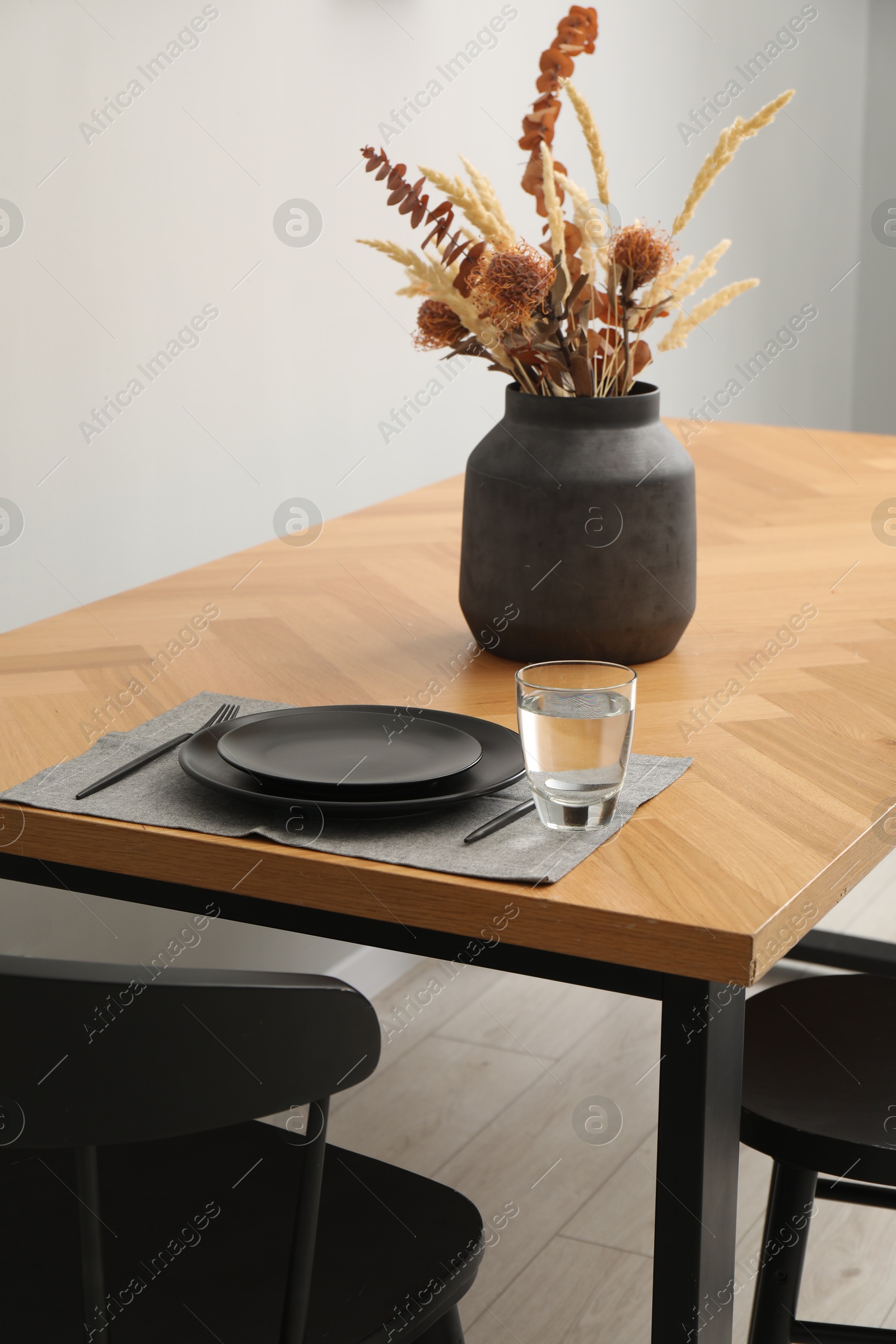 Photo of Stylish table setting with black dishware in dining room