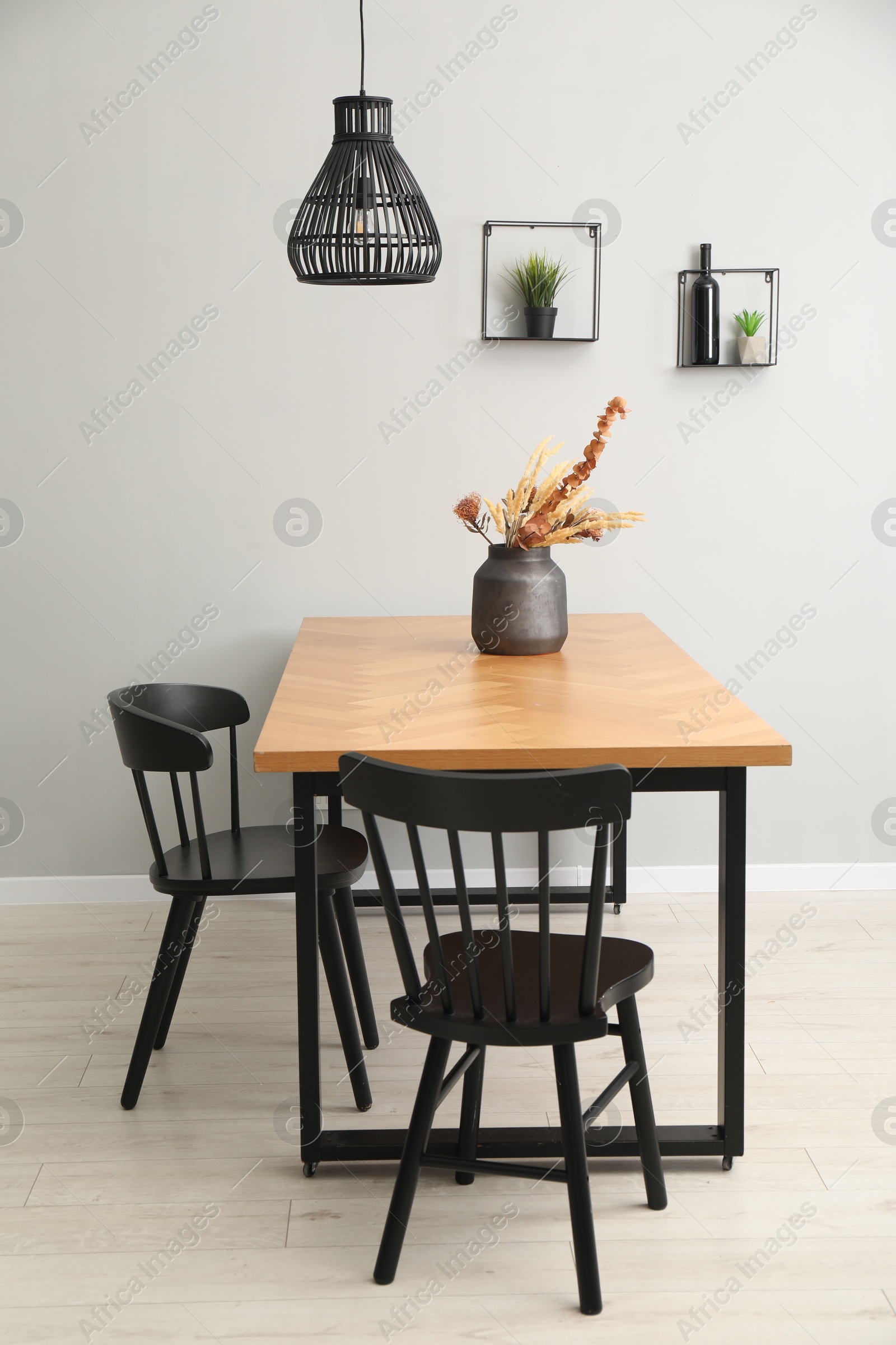 Photo of Wooden table with black chairs in stylish dining room