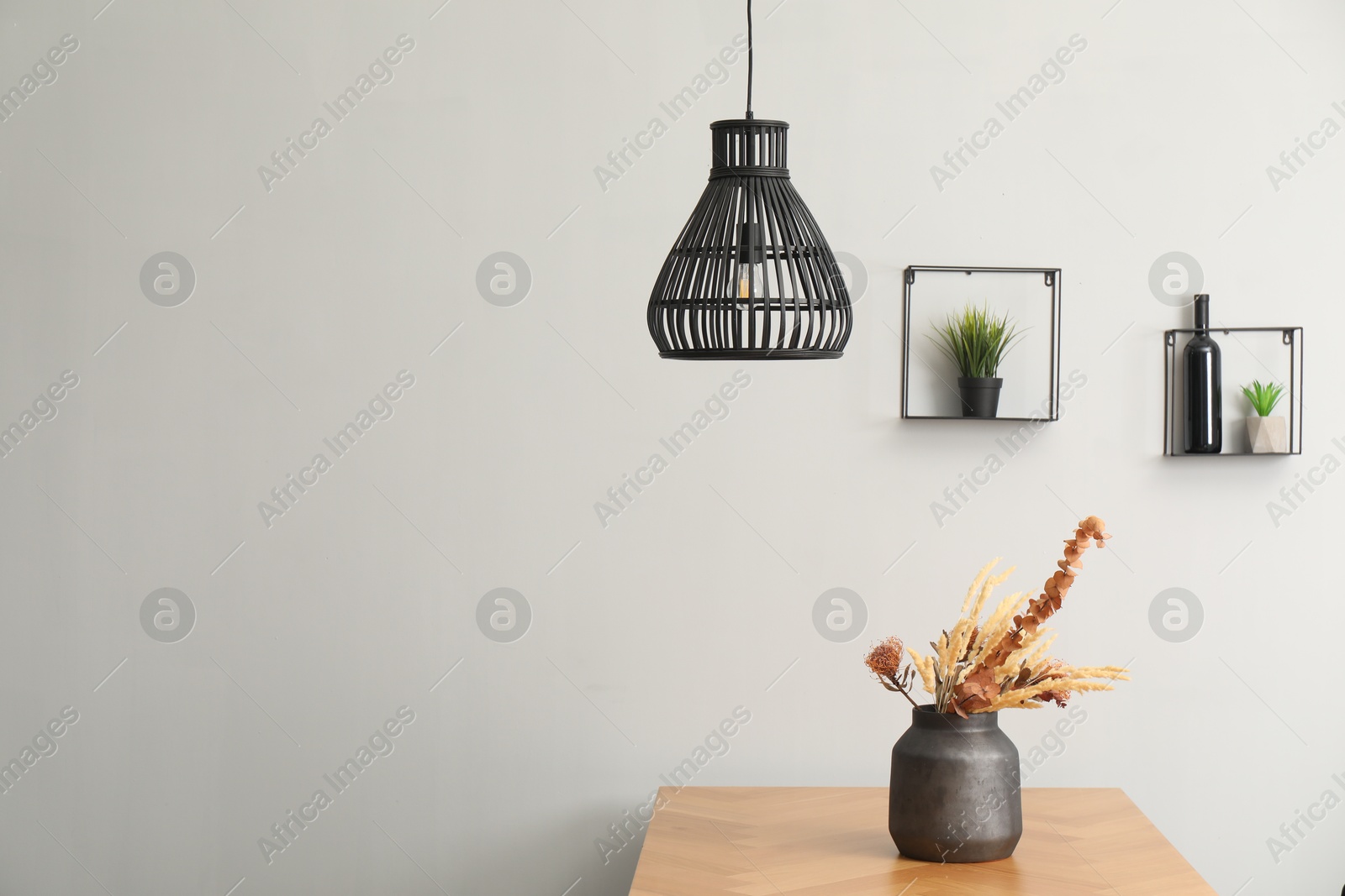 Photo of Vase with bouquet of dried flowers on wooden table indoors. Space for text