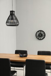 Photo of Wooden table with black chairs in stylish dining room