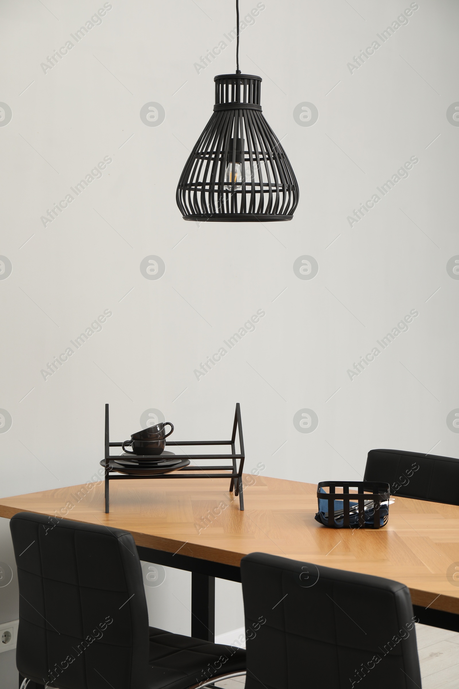 Photo of Wooden table with black chairs in stylish dining room