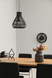 Photo of Wooden table with black chairs in stylish dining room